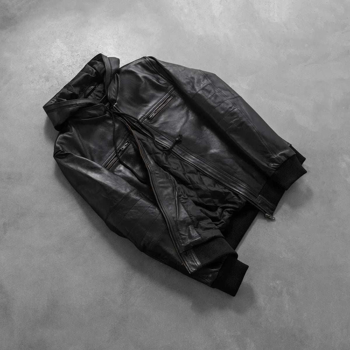 
Perspective portée de Bouncer Biz Black Leather Hooded Bomber Jacket sur modèle - Tombé naturel à la lumière du jour